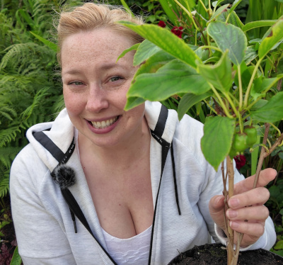 Amy Kelly smiling and holding a plant